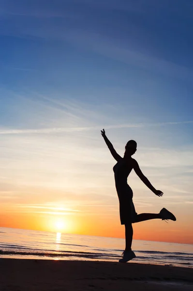 Disfrutando de la puesta de sol de verano. Mujer alegre silueta bailando en — Foto de Stock