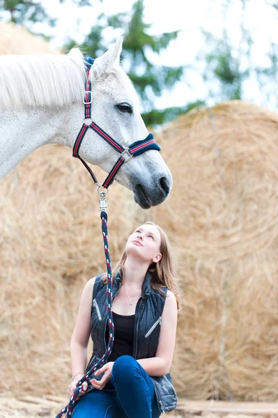 Mladá dospívající dívka majitel seděl u svého bílého koně. — Stock fotografie