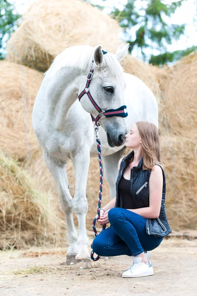 Mladá dospívající dívka majitel seděl u svého bílého koně — Stock fotografie