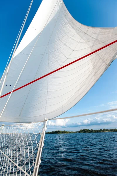 Vita yacht segel i solljus på blå molnig himmel bakgrund. — Stockfoto