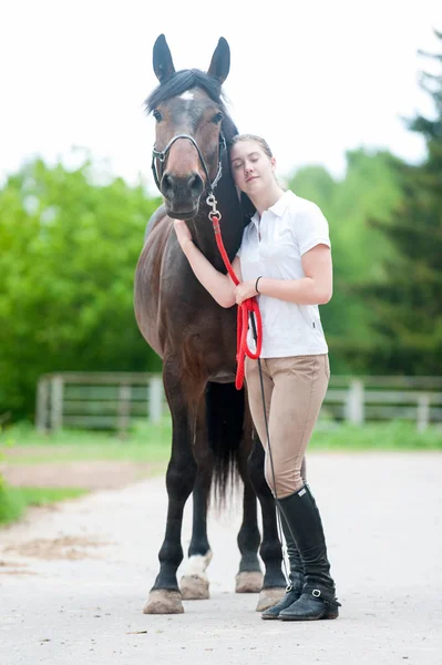Junges Teenager-Mädchen umarmt ihr Lieblingspferd aus Kastanien. — Stockfoto
