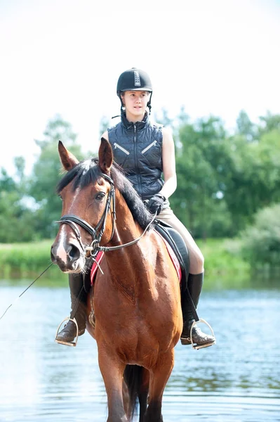 Joven adolescente cabalgando a caballo desde el lago temprano en la mañana —  Fotos de Stock