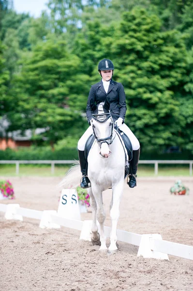 Teenage girl equestrian in dress uniform riding horseback on are — Stock Photo, Image