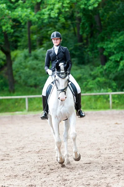 Adolescente menina equestre em vestido uniforme montando cavalo em são — Fotografia de Stock