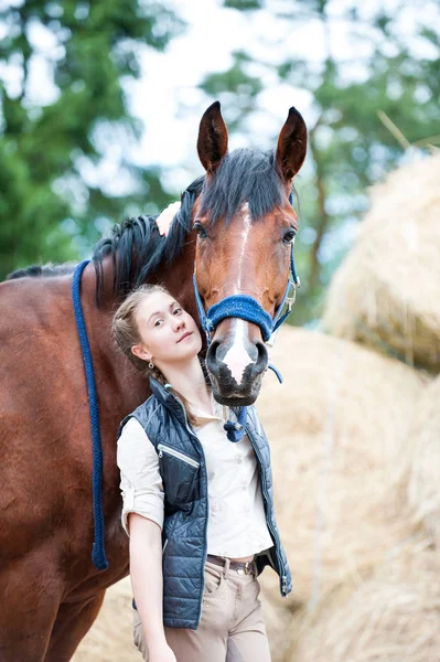 Junge hübsche Teenager-Reiterin umarmt ihr Lieblingspferd — Stockfoto