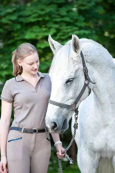Hezká mladá dospívající dívka vede bílý kůň — Stock fotografie