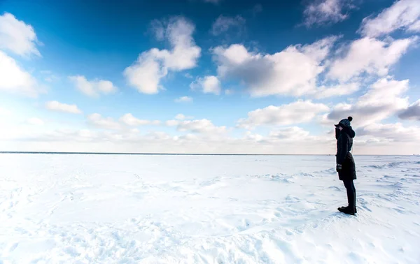 Kız donmuş deniz uzağa bakarak kenarında ayakta — Stok fotoğraf