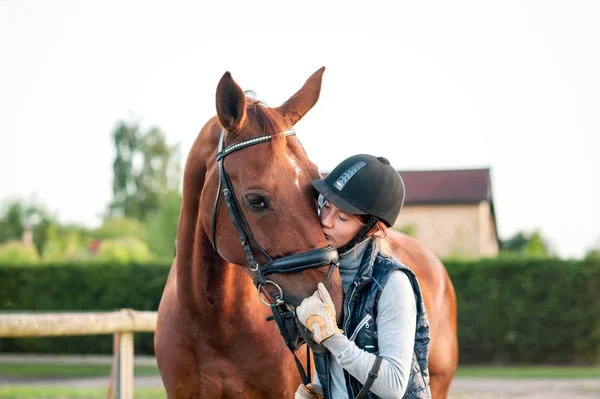 Joven adolescente ecuestre besando a su caballo rojo favorito — Foto de Stock