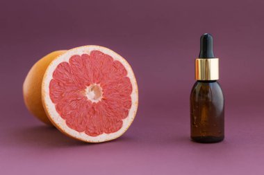 Üniformalı arka planda yüz için doğal kozmetik ürünleri olan güzel bir şişe. Doğal cilt bakım ürünü. Gerekli yağ ve aromaterapi.