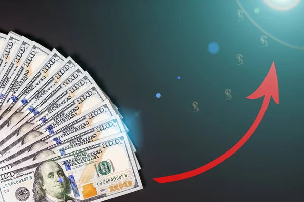 Closeup of one hundred dollars banknote on black background. Business finance and money concept, red arrow growing graph