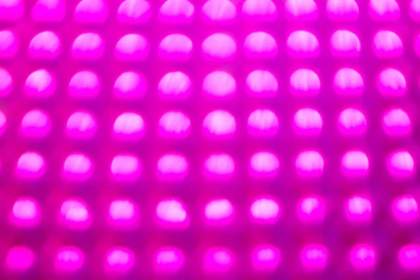 Parlak pembe arka planda renkli ışıklar. Tatil konsepti. Şenlikli