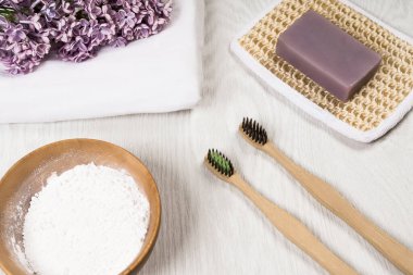 Çevre dostu bambu diş fırçaları, el yapımı sabun, diş pudrası, ahşap arka planda keten kumaş. Sıfır atık. Sürdürülebilir yaşam tarzı. Plastiksiz konsept.