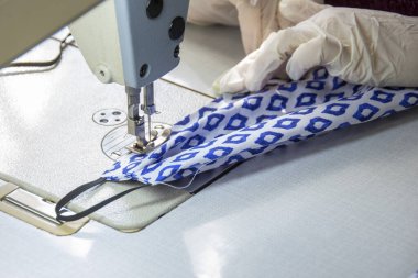 Dikiş makinesine koruyucu bir maske dikmek. Nisan, 3, 2020. Odessa 'da. Ukrayna. Meslek Fakültesi