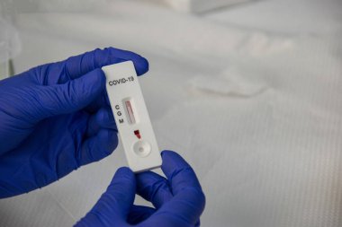 Mavi koruyucu eldivenli sıhhiyenin elleri COVID-19 testine giriyor.