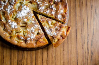 Tahta tabakta dilimlenmiş elmalı turta.