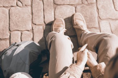 Sırt çantalı bir adam parkta bankta oturuyor.