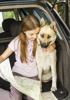Arabada köpeği olan genç bir kız.