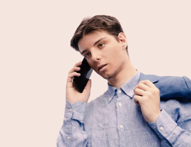 Genç adam telefonda konuşuyor.