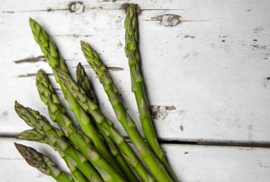 Bahçedeki kırsal beyaz masada yeşil kuşkonmaz sebzesi.
