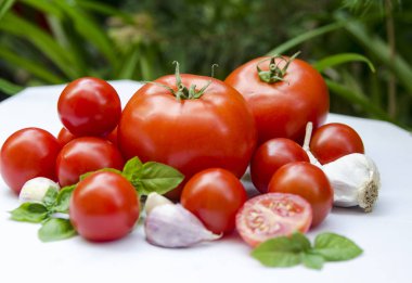 Masada taze domates ve fesleğen var.