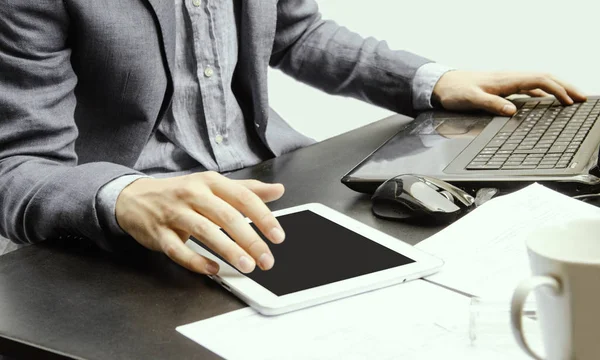 Dizüstü bilgisayar ve dijital tabletle çalışan iş adamı