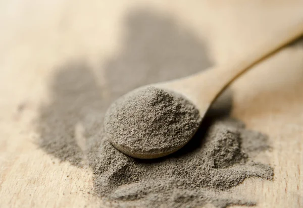 Siyah arkaplanda un olan tahta kaşığı kapat.