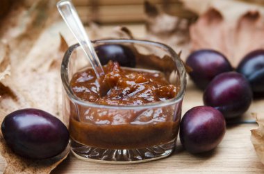 Ahşap bir masada, bir bardakta erik reçeli.