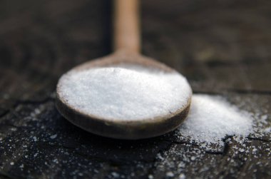 Tahta masada kaşıkta şeker tozu