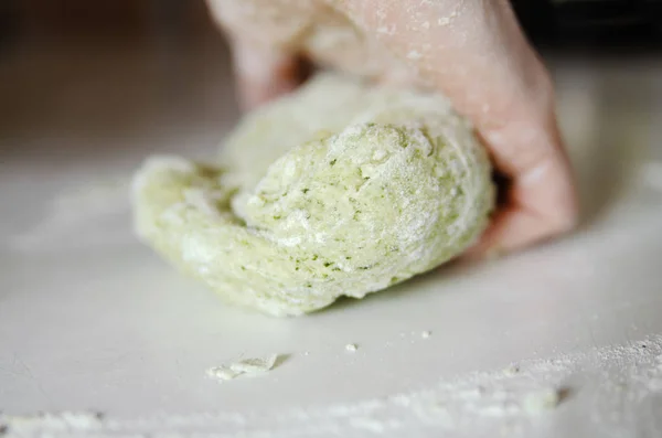Hand made vegetable dough for pasta. Close up on woman hand mix fresh green dough