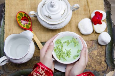 Kadınların elinde bitkisel yeşil çay fincanını yakın.