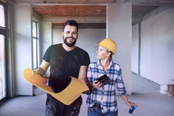 İnşaat alanında inşaat mühendisi olan kadın ve erkek inşaat mühendisi bina içindeki inşaat işleri hakkında konuşuyor. İki inşaatçı profesyonel konuşuyor.