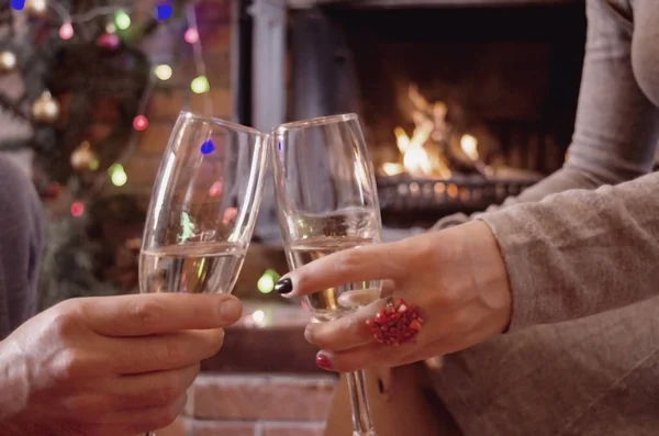 two people toasting with champagne glasses at home