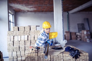 İnşaat alanında miğferi olan bitkin bir mimar. Evi yenilemek için kadın inşaat mühendisi kontrol materyali