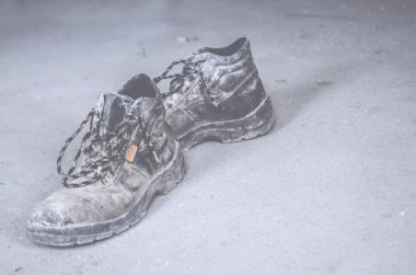 Eski kirli ayakkabılar yerde.