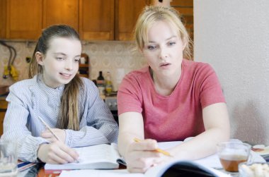 Anne ve kızı evde ödev yapıyor. 