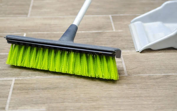 Broomstick with plastic fibers cleaning the floor, Housekeeping and sweeping with broom