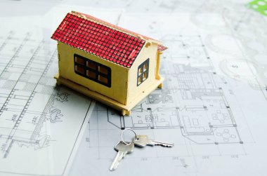 Mimari proje üzerine ev modeli. Yeni evin anahtarlarıyla mavi baskı. Boş bir ev için yatırım. Banka kredi kavramı.