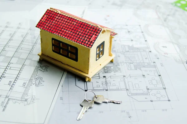 House model on architectural project paper with keys of new home. Investment for vacant house. Bank credit concept.