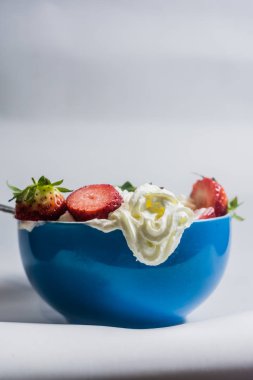 Mavi bardakta kremalı çilek.