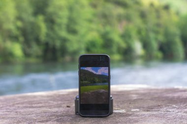 Nehir kıyısında cep telefonu kullanan kadınların ellerini kapat.