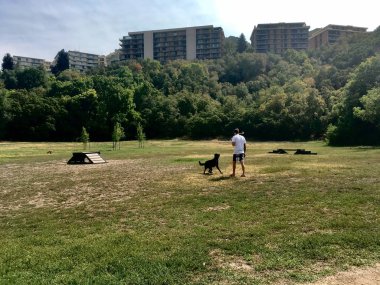 Siyah köpeğiyle oynayan bir adam.