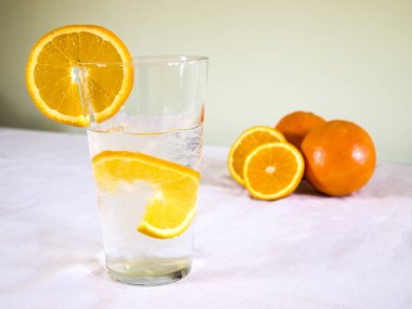 Buz ve portakal dilimli soğuk su. Yaz için sağlıklı ve ferahlatıcı bir içecek.