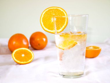 Buz ve portakal dilimli soğuk su. Yaz için sağlıklı ve ferahlatıcı bir içecek.