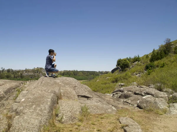 Молодой аргентинский фотограф фотографирует на вершине скалы — стоковое фото