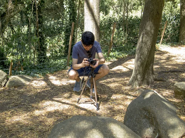 Молодой аргентинский фотограф фотографируется с треногой в лесу — стоковое фото
