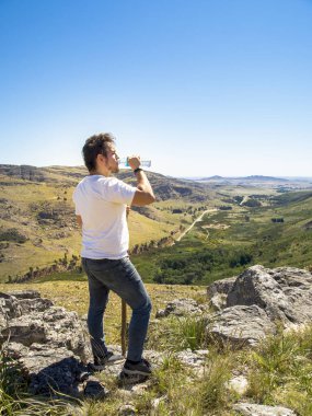 Genç yürüyüşçü Cerro Bahia Blanca 'da su içiyor.