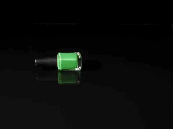 Bottiglia smalto verde sdraiato su sfondo nero con refection — Foto Stock