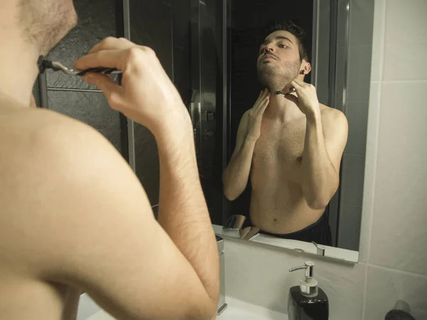 Portrét hezkého kavkazského teenagerského odlesku ze zrcadla, holení žiletkou — Stock fotografie