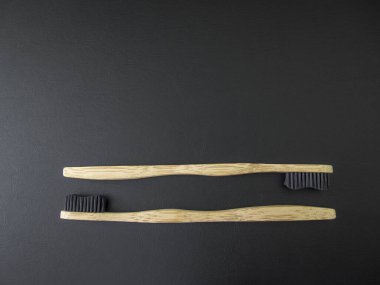 Siyah arka planda çevre dostu Bambu diş fırçası. Sıfır atık, plastik yok. Boşluğu kopyala.