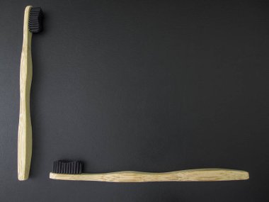 Siyah arka planda çevre dostu Bambu diş fırçası. Sıfır atık, plastik yok. Boşluğu kopyala.